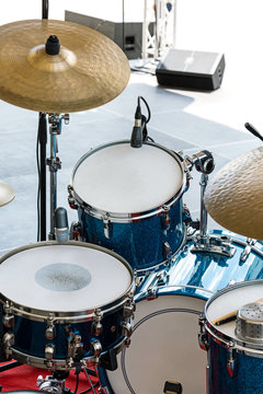 drum set standing on outdoor stage for performance of street musicians