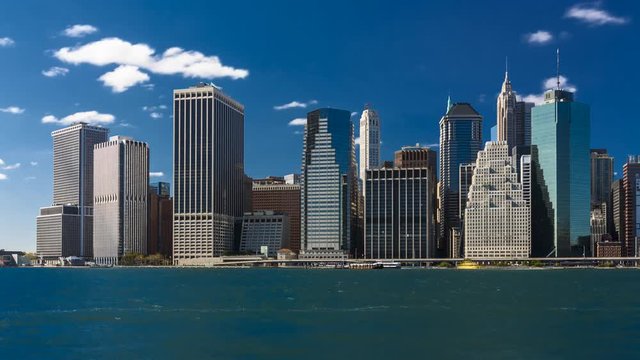 Time lapse! Fluffy clouds over financial district, Manhattan Island, New York City. Seen from Brooklyn. 
