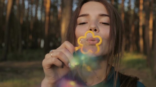 Lovely girl blowing soap bubbles