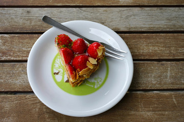Delicious Strawberry Cheesecake on the white plate on the wooden table top