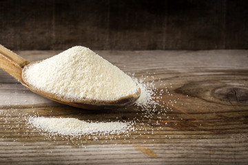 Organic semolina or couscous wheat in wooden spoon