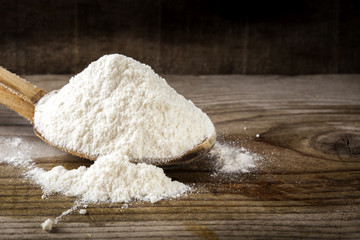 Organic wheat flour in wooden spoon