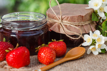Traditional homemade strawberry jam in a jars, decorated with fresh strawberries