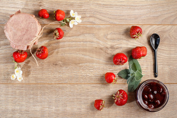 Traditional homemade strawberry jam in a jars, decorated with fresh strawberries