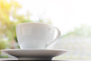 coffee cup clock and news paper on old wooden table nature background