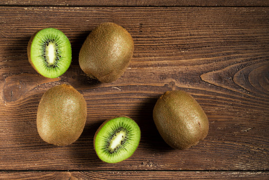 Kiwi fruits on wooden background, top view with copy space