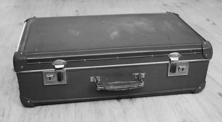 Old leather suitcase on wooden floor. Vintage
