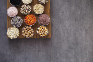 Various superfoods, seeds, cereals, grains on a gray background. Healthy eating concept. Top view, copy space
