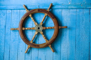 Blue wall, superannuated, old wooden steering of a vessel 