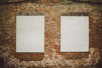 Old brick wall with two large windows covered over with white material