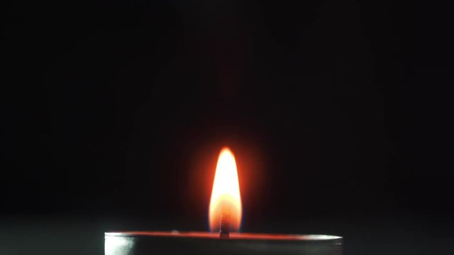 Chemical experiments with ignition of reagents: glass flask with chemical fluid is held over fire. Candle burns and heats the chemical reagent. Chemical burner.