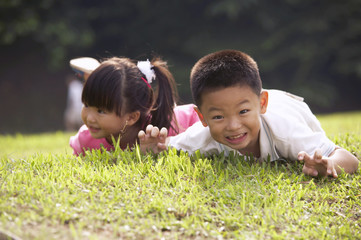 boy and girl laying on the grass