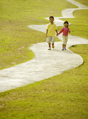 Boy and girl walking hand in hand at the park