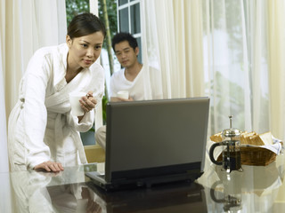 woman focus on laptop with man behind her