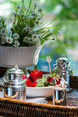 Strawberries on a table with flowers and vases