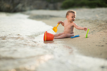 Little child girl playing on sea beach. Summer vacation