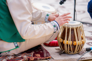 man plays on classical drums of Tajikistan