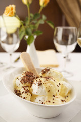 Egg white with vanilla mousse arranged on a plate, Wineglass in background, Traditional dessert in elegant setting, Selective focus with soft light