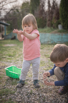 Brother and sister playing in yard with sones
