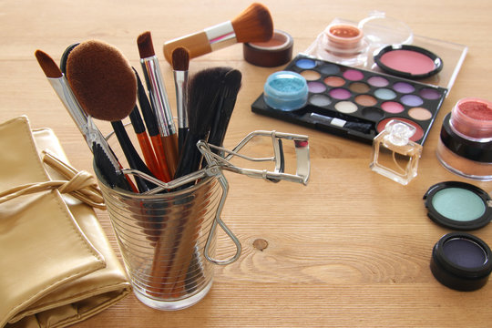 makeup cosmetics beauty tools and brushes on wooden background