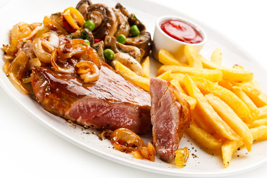 Grilled beef steak with french fries on white background 