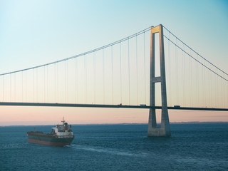 Öresundbrücke mit einem Frachter im Sonnenuntergang 