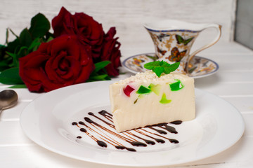 Fruit jelly with pieces of apricot on a plate and a spoon on an old wooden table. Selective focus