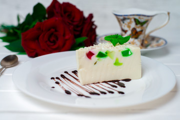 Fruit jelly with pieces of apricot on a plate and a spoon on an old wooden table. Selective focus