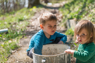 Brother and sister playing with old pot