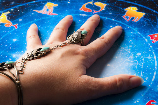astrologer fortune teller hand over esoteric background with zodiac signs like astrology concept 
