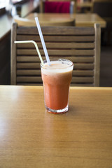Fruit cocktail glass in cafe or restaurant - selective focus point. Healthy orange organic juice 