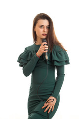 Vertical portrait of beautiful woman in green dress sings a karaoke in microphone