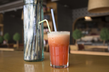 Fruit cocktail glass in cafe or restaurant - selective focus point. Healthy orange organic juice 