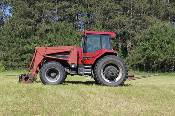 Red Farm Tractor on a green grass pasture