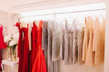 Grate choice of gorgeous fashion dresses hanging on racks in woman's wardrobe. A big variety of...