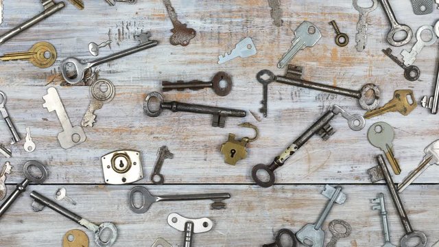 Time lapse of  many different old keys in a mess on wooden background 
