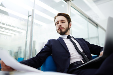 Young manager concentrating on reading financial papers