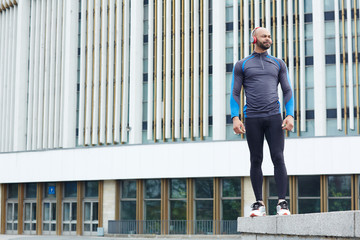 Sportsman with headphones on background of modern architecture