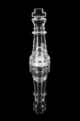 Glass chess king on black isolated background.