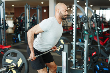 Fototapeta na wymiar Strong man lifting weight in gym