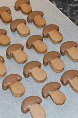 chocolate christmas biscuits in the shape of mushrooms drying on the baking paper - 162051516