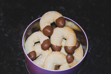 vanilla rolls dipped in chocolate in a tin, freshly baked christmas cookies - 162051589