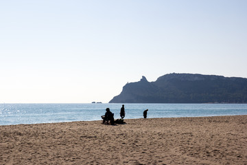Spiaggia del Poetto, pomeriggio, con persone, Cagliari. Sella del Diavolo sullo sfondo.