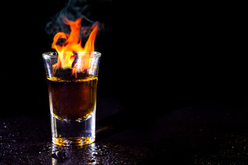 Hot alcoholic cocktail burning in shot glass. © peterkai
