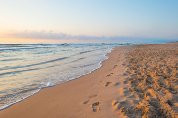 Sunrise over sea and sandy beach in spring