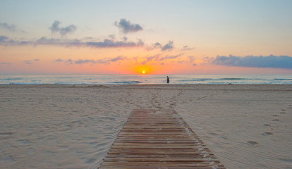 Fototapeta na wymiar Sunrise over sea and sandy beach in spring