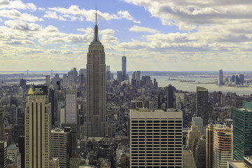 View of the Empire State Building  and lower Manhattan as seen from the Rockefeller Center. Afternoon, cloudy skies