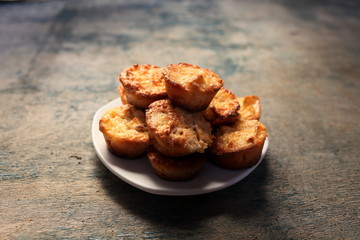 White dish with muffins on a wooden background.
