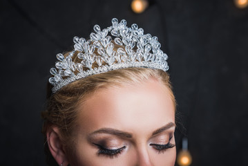 Beautiful woman in crown on dark background © Selora