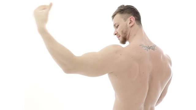 Bodybuilder flexing his muscles. Athlete demonstrates biceps and winks